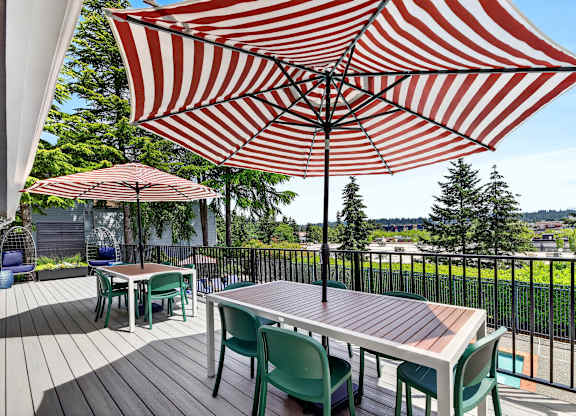 A patio with a table and chairs under a striped umbrella.