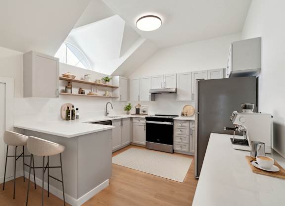 A modern kitchen with a white countertop and a black refrigerator.