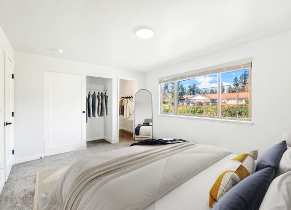 a bedroom with a bed and a large window