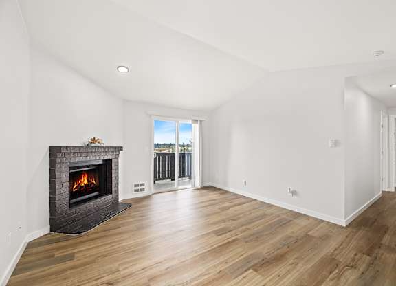 a living room with a fireplace and a door to a balcony