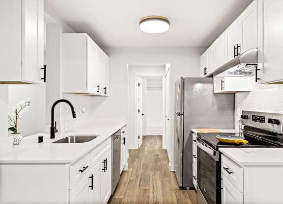 a kitchen with white cabinets and a stainless steel refrigerator