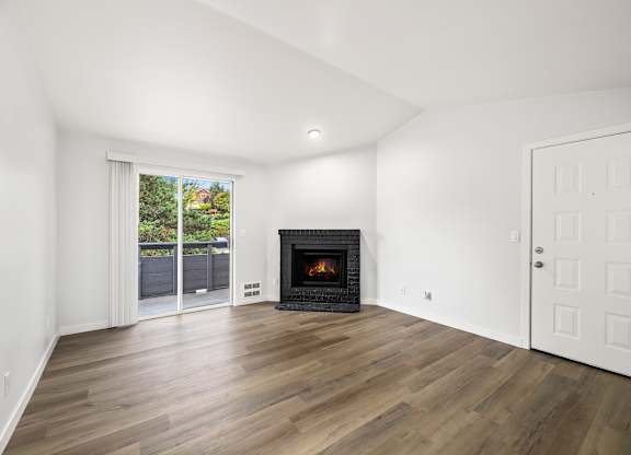 a living room with a fireplace and a door to a patio