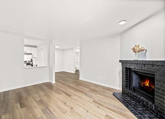 a living room with a fireplace and wooden floors