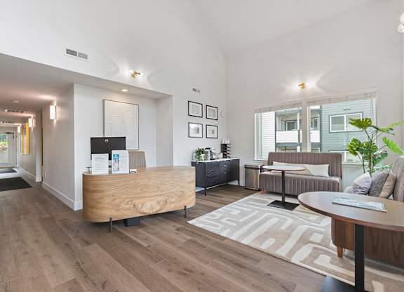 A modern living room with a wooden reception desk and a couch.