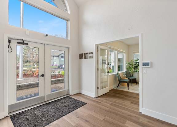 A white interior with a black rug and a glass door.