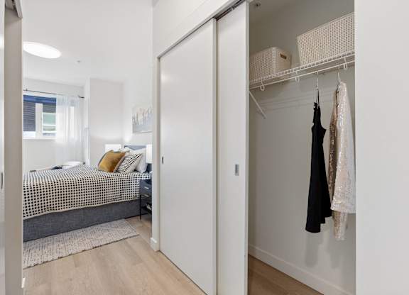 A bedroom with a bed, a wardrobe, and a window.