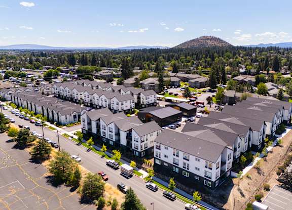 A large apartment complex with a parking lot in front.