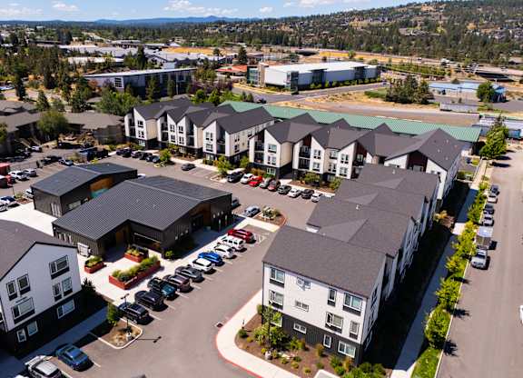 A large parking lot is surrounded by apartment buildings.