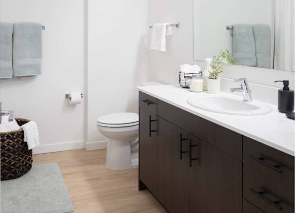 A bathroom with a white sink and a white toilet.