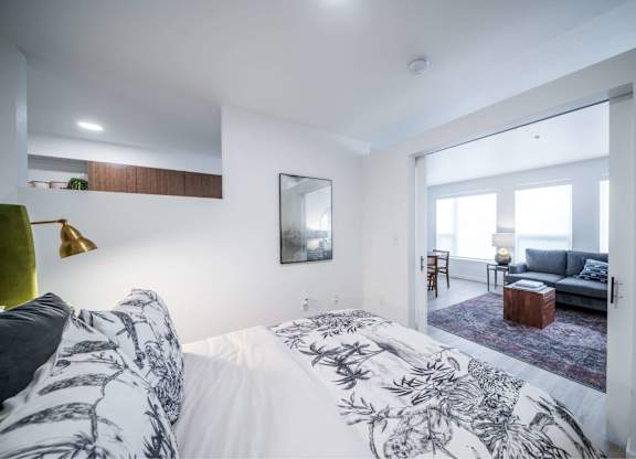 A bedroom with a large bed and a mirror on the wall.
