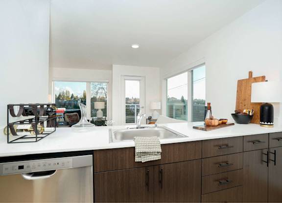 A modern kitchen with dark wood cabinets and a white countertop.