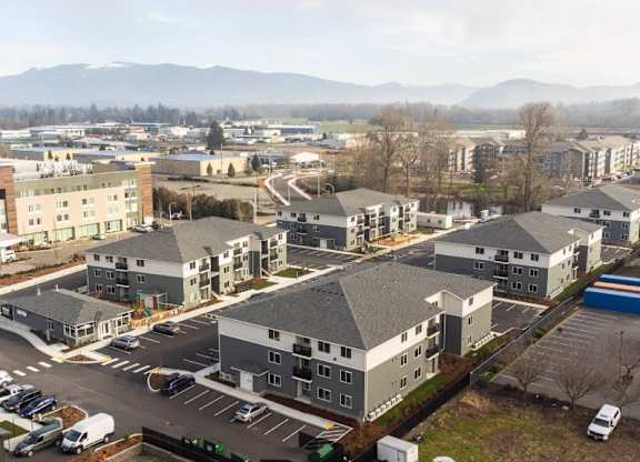 A large building complex with a parking lot in front.