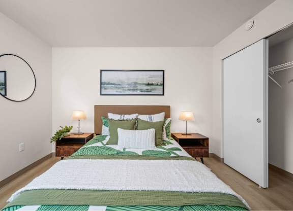 A bedroom with a large bed and a painting above it.