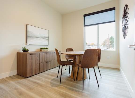 A dining room with a wooden table and chairs.