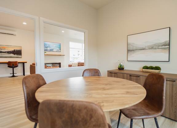 A dining room with a wooden table and chairs.