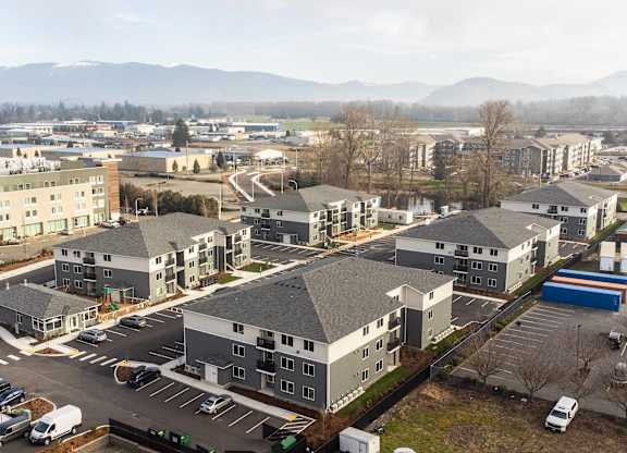 A large building complex with a parking lot in front.