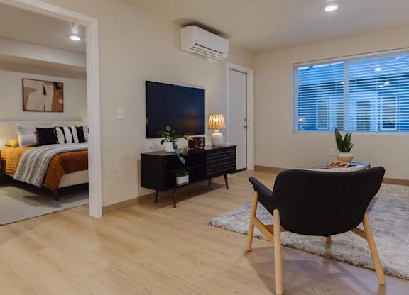 A modern living room with a black chair and a television.