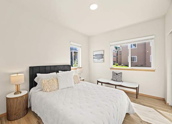 A bedroom with a large bed and a window overlooking a building.