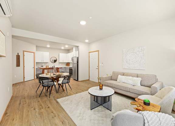 A modern living room with a dining table and grey couch.