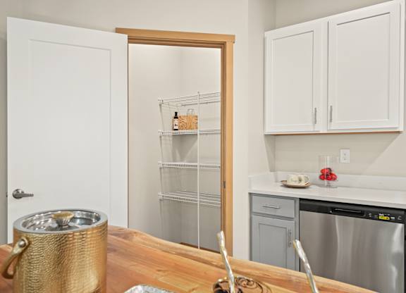A kitchen with a white door, a white fridge, and a white counter.