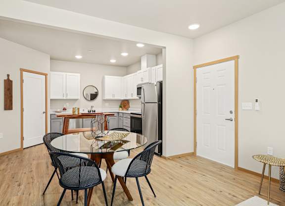 A kitchen with a dining table and chairs.