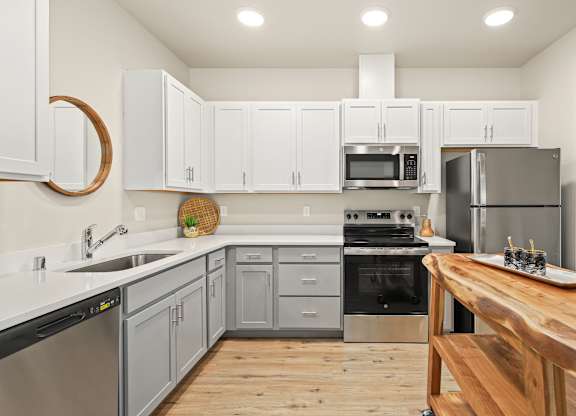 A modern kitchen with wooden countertops and stainless steel appliances.