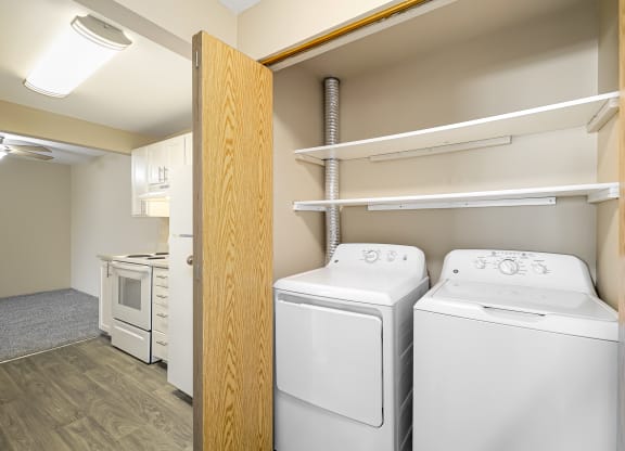 a white washer and dryer in a room with a door to a closet