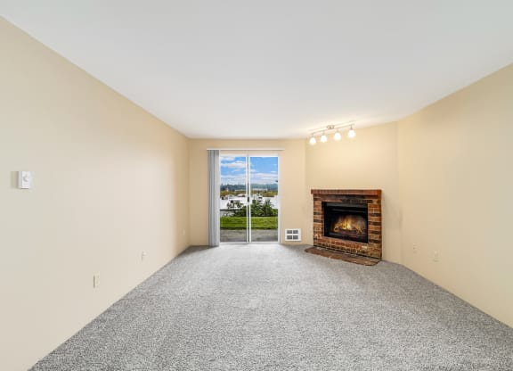 a living room with a fireplace and a door to a balcony