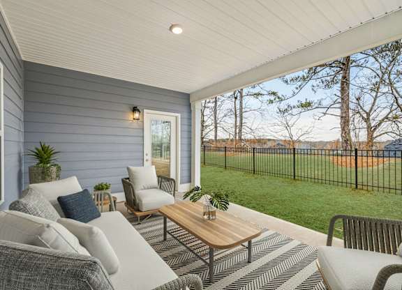 A patio with a sofa, chairs, and a coffee table.