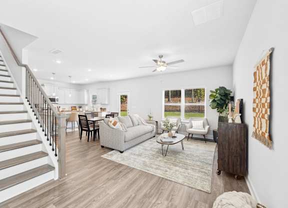 A spacious living room with a staircase on the left side.
