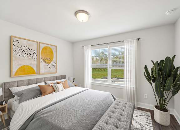 A bedroom with a large bed and a cactus plant.