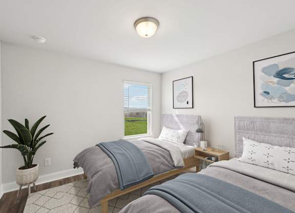 A bedroom with two beds and a potted plant.