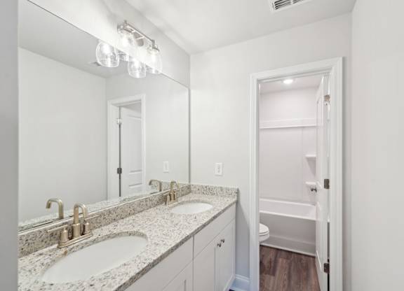 Secondary bathroom with double vanity and tub shower