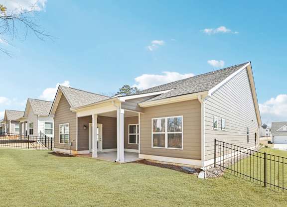 A house with a grey siding and a black fence.