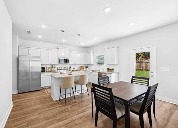 A modern kitchen with a dining table and chairs.