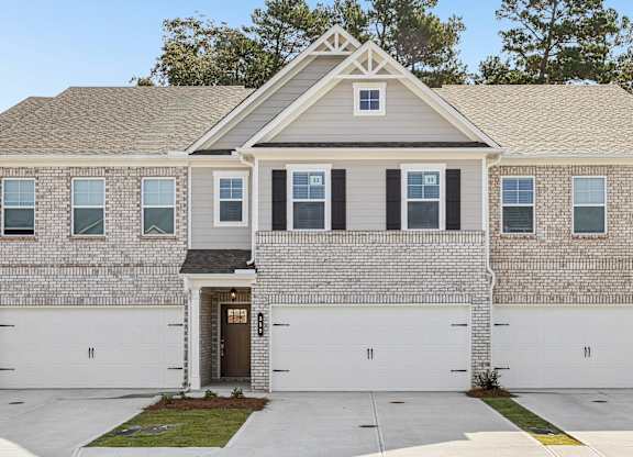 Exterior shot of the Westport floorplan, two story townhome with a private driveway and attached garage.