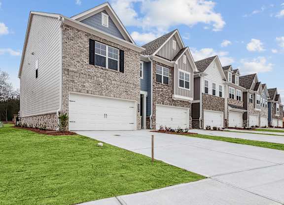 Side view of Carlton Crossing with a private driveway and attached garage.