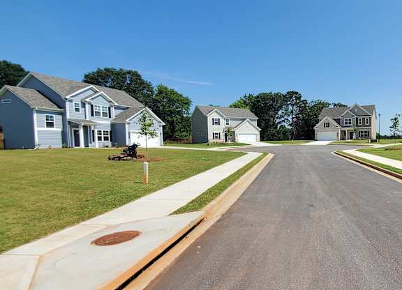 A street in a residential neighborhood with houses on both sides.