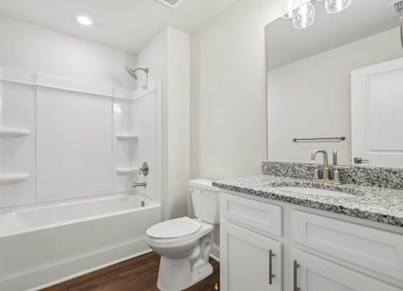 A white bathroom with a toilet, sink, and bathtub.