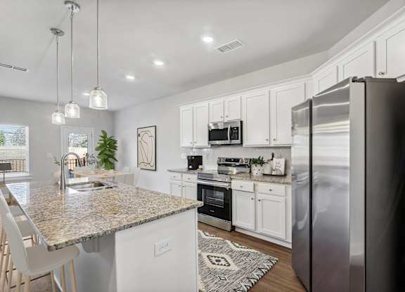Spacious kitchen with an island, ample storage, stainless steel appliances and view into the backyard.