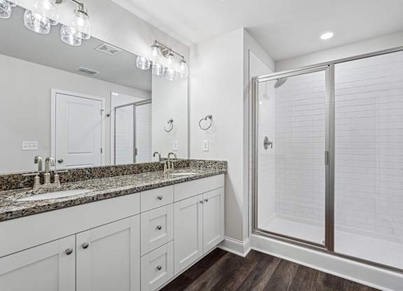 Primary bathroom with double vanity, walk-in shower and walk-in closet.
