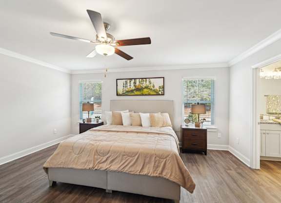 A bedroom with a bed, nightstand, and a painting on the wall.
