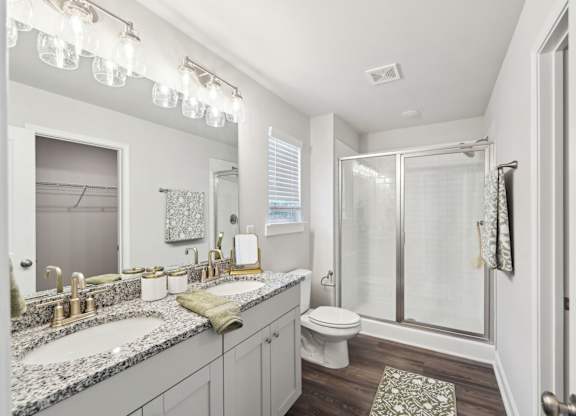 A bathroom with a sink, toilet, and shower.