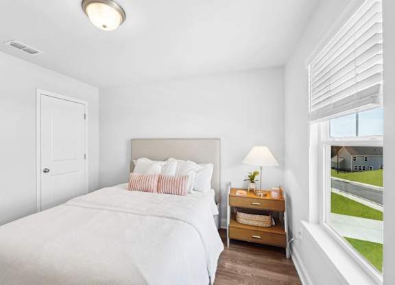 A bedroom with a large bed and a window overlooking a street.