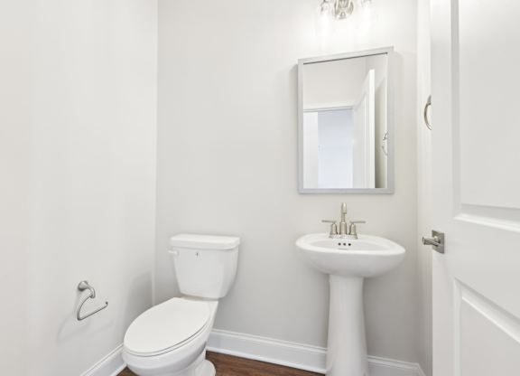 A white toilet and sink in a small bathroom.