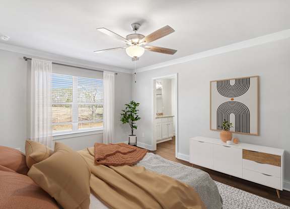 Another view of the spacious primary suite showcasing a grand bed and modern ceiling fan.