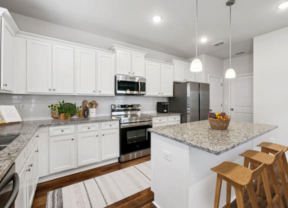 4-bedroom single family home with spacious kitchen. Open-floor plan concept with kitchen island, ample storage and bar seating.