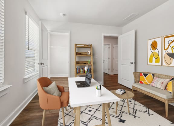 a living room with a white desk with a laptop on it