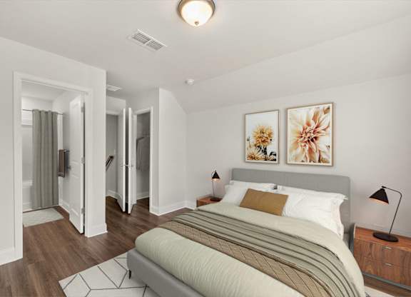A bedroom with a bed, nightstand, and two framed pictures on the wall.