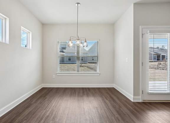 A room with a large window and a wooden floor.
